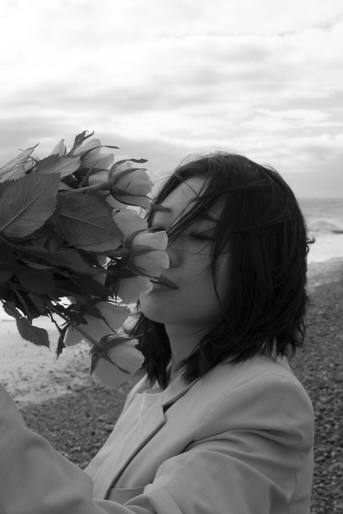 black and white photograph of woman smelling flowers
