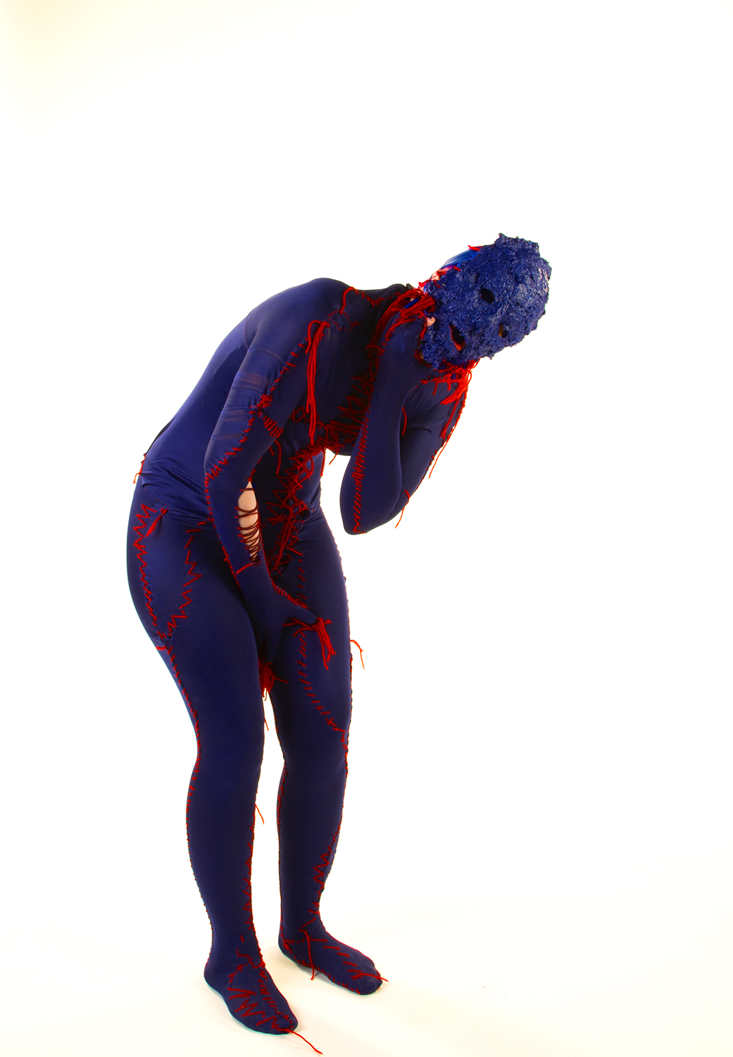 Human figure bent over covered in purple with a textured purple face with blood red fibres coming from the neck and parts of the body