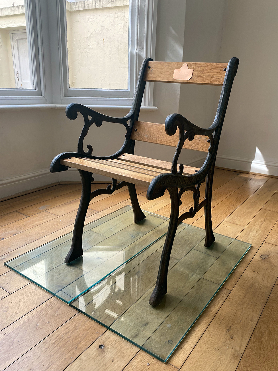 Wood and cast-iron chair with brass plaque