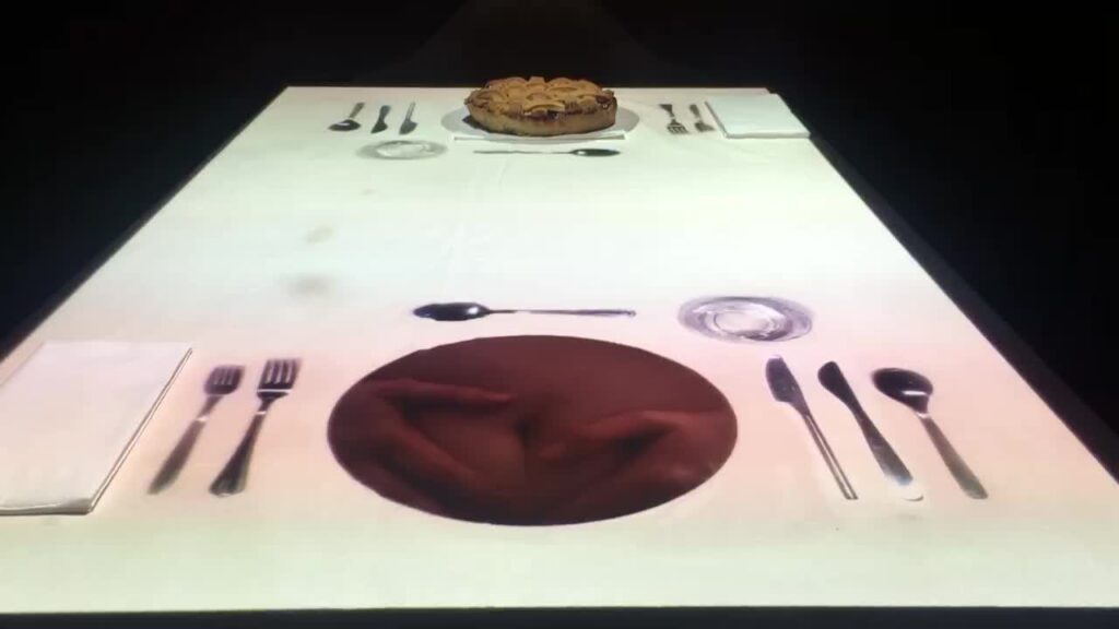 Image of a table setting printed on a table white table cloth with a real cherry pie on an image of a plate