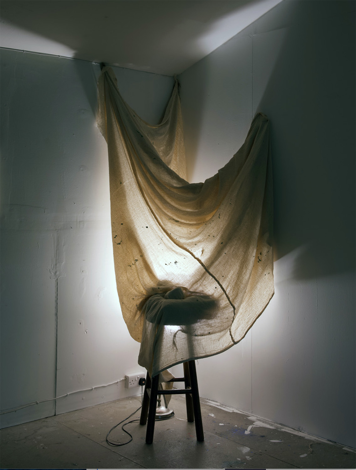 seat draped with cloth and light behind it